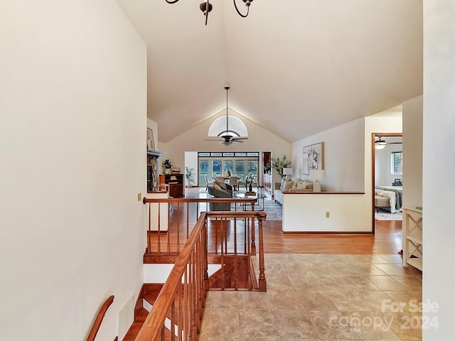 hall with lofted ceiling and light hardwood / wood-style flooring