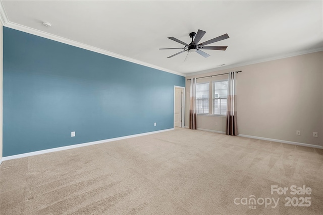 carpeted spare room featuring ceiling fan, ornamental molding, and baseboards