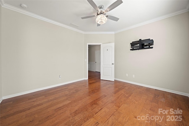 empty room featuring a ceiling fan, baseboards, wood finished floors, and ornamental molding