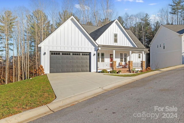 modern farmhouse style home featuring covered porch, a front yard, and a garage