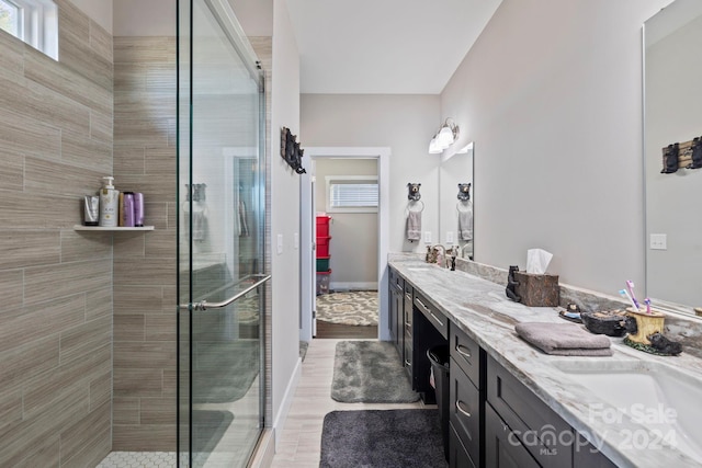 bathroom with hardwood / wood-style floors, vanity, and an enclosed shower