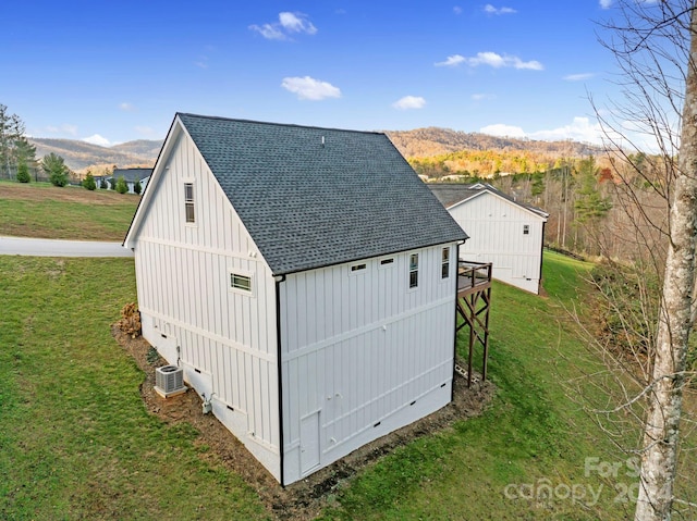 view of outbuilding featuring a mountain view, a lawn, and central AC