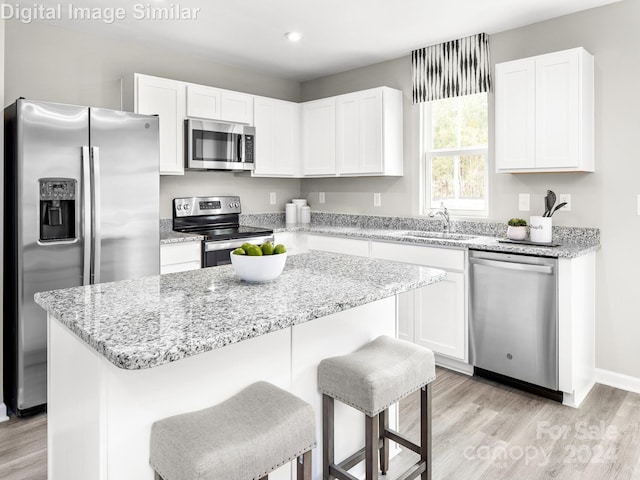 kitchen with white cabinetry, appliances with stainless steel finishes, and a center island