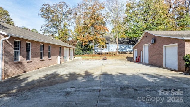 exterior space with a garage and an outbuilding