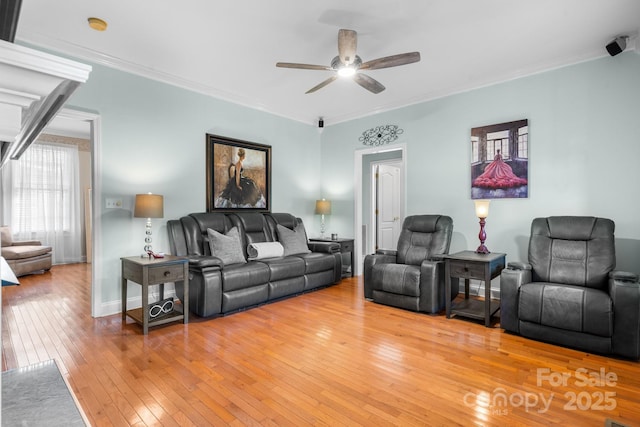 living room featuring ceiling fan, light wood-type flooring, and ornamental molding