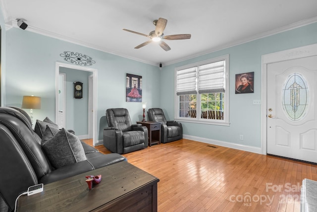 living room with hardwood / wood-style flooring, ceiling fan, and ornamental molding