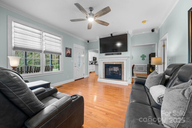 living room with hardwood / wood-style floors, ceiling fan, and crown molding