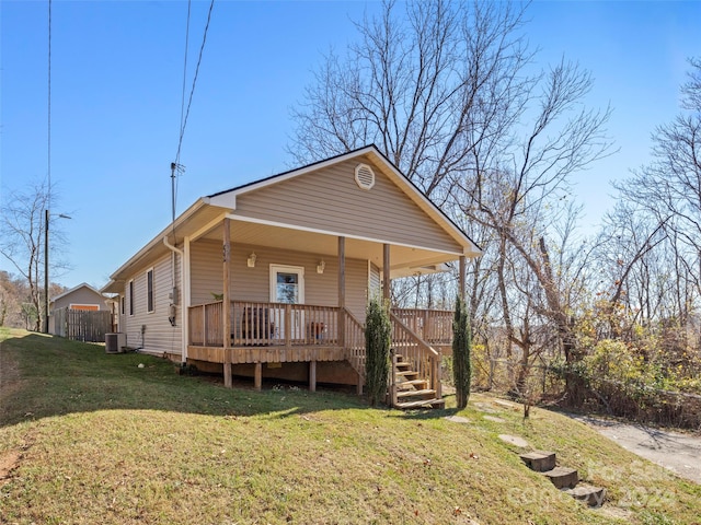 view of front of home featuring a front yard, central AC unit, and covered porch