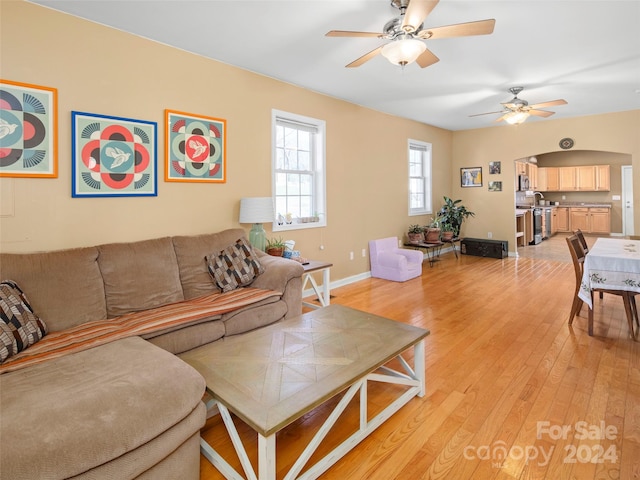 living room with ceiling fan and light hardwood / wood-style flooring