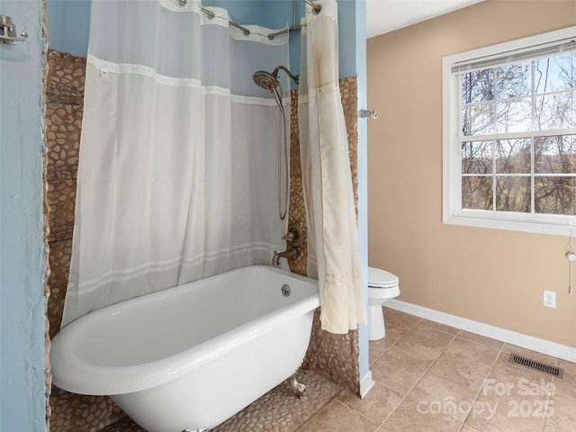 bathroom with tile patterned floors, toilet, and shower / tub combo