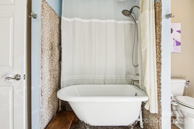 bathroom with a washtub and toilet