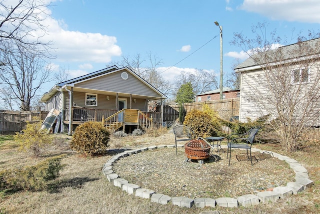 rear view of house with a deck and a fire pit