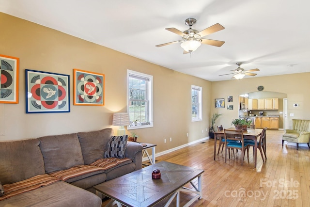 living room featuring light hardwood / wood-style flooring and ceiling fan