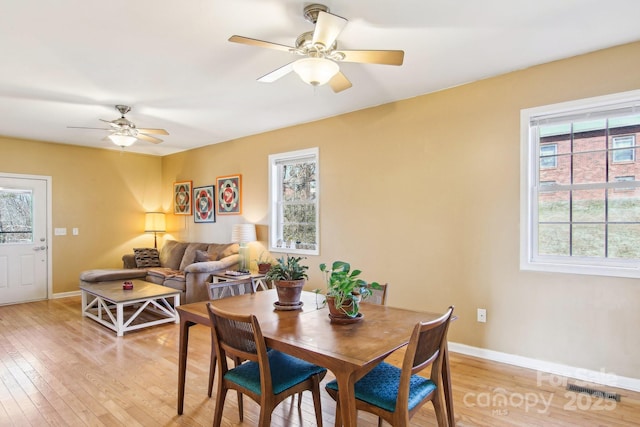 dining space featuring a healthy amount of sunlight, ceiling fan, and light hardwood / wood-style flooring