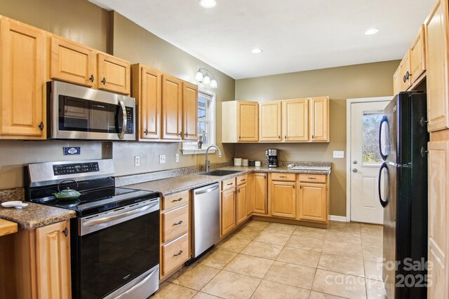 kitchen featuring appliances with stainless steel finishes, light brown cabinetry, sink, and light tile patterned floors