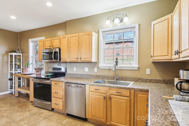 kitchen featuring light brown cabinetry, sink, light tile patterned floors, and appliances with stainless steel finishes