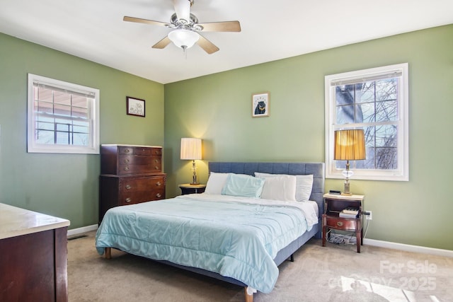 carpeted bedroom featuring multiple windows and ceiling fan