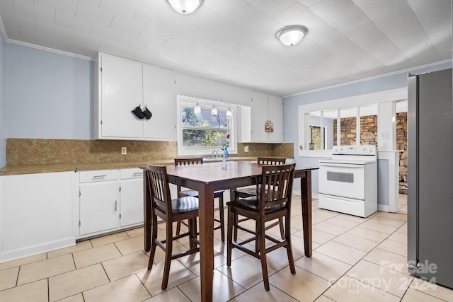 tiled dining space featuring crown molding