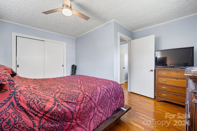 bedroom featuring ceiling fan, a textured ceiling, light hardwood / wood-style floors, and crown molding