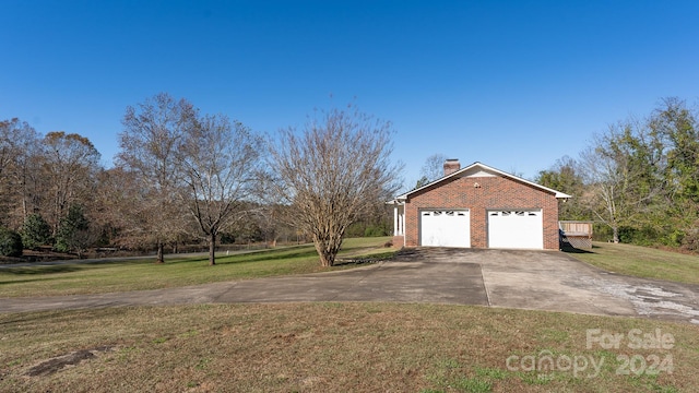 exterior space with a yard, a deck, and a garage