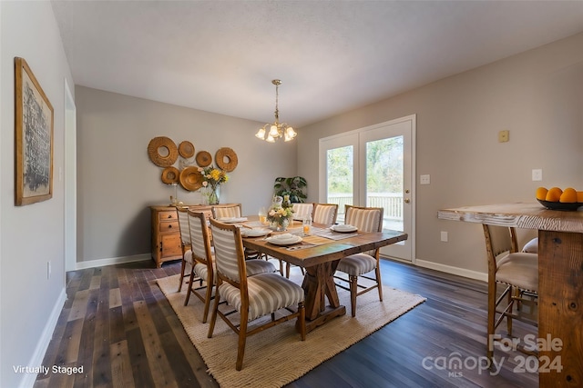 dining room with dark hardwood / wood-style flooring and an inviting chandelier