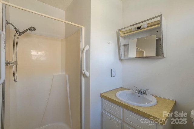 bathroom featuring a shower and vanity