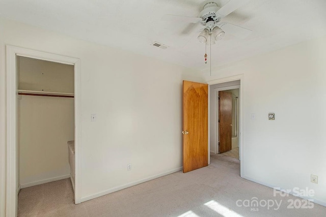 unfurnished bedroom with ceiling fan, light colored carpet, and a closet