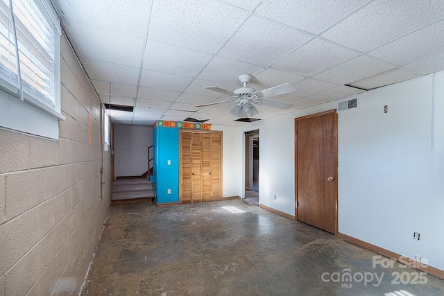 basement featuring ceiling fan and a drop ceiling