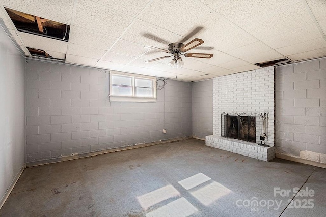 basement featuring a fireplace and ceiling fan