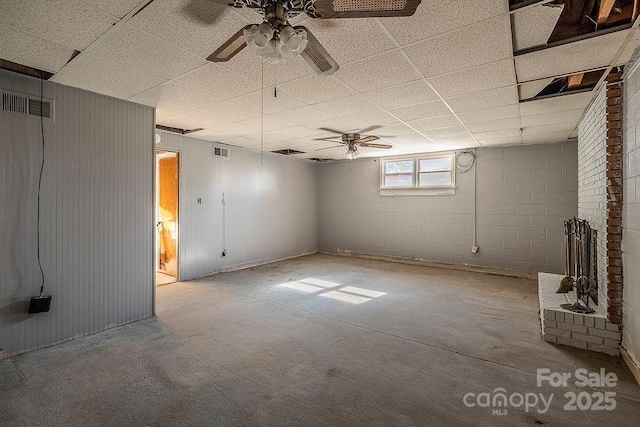 basement with a drop ceiling and ceiling fan