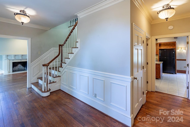 staircase with crown molding and wood-type flooring