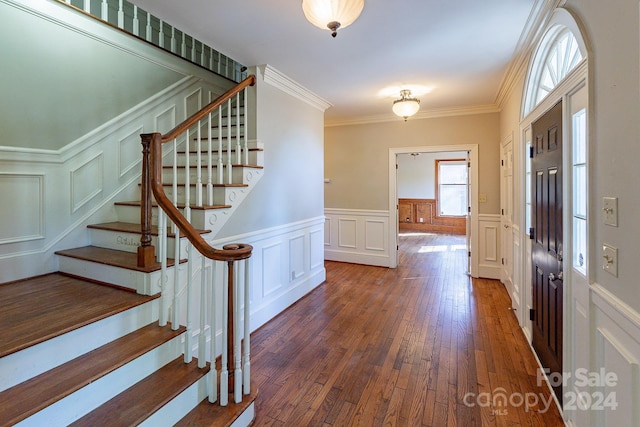 entryway with dark hardwood / wood-style flooring and ornamental molding