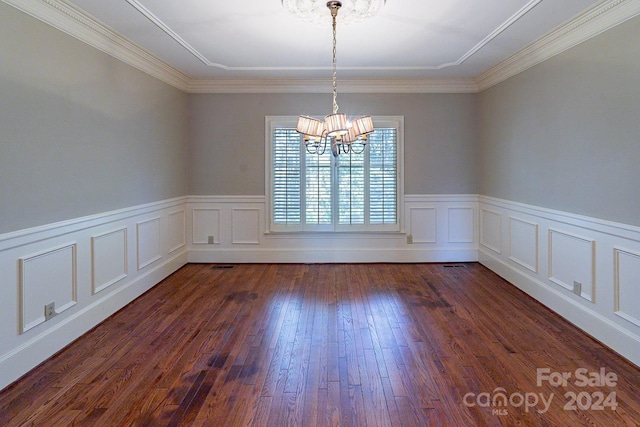 spare room with ornamental molding, dark wood-type flooring, and an inviting chandelier