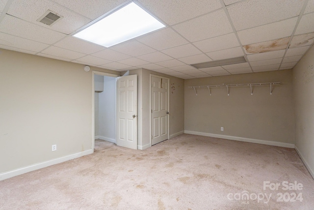 basement with light colored carpet and a drop ceiling