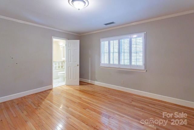 spare room with crown molding and light hardwood / wood-style floors