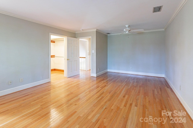 spare room with ceiling fan, light wood-type flooring, and ornamental molding