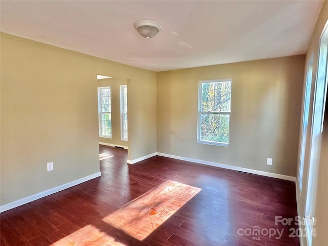 spare room featuring dark wood-type flooring