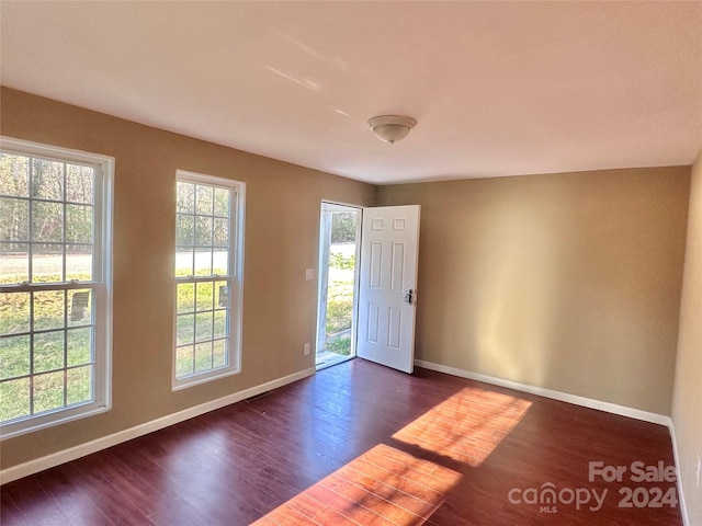 empty room with dark hardwood / wood-style flooring