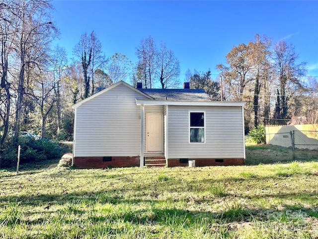 rear view of house featuring a lawn