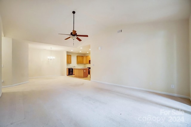 unfurnished living room featuring ceiling fan with notable chandelier and light colored carpet