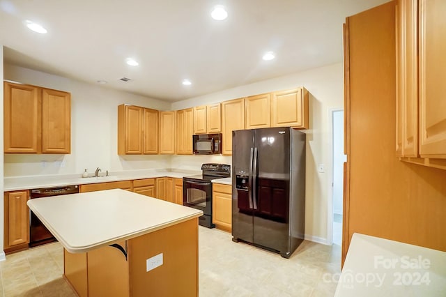 kitchen featuring black appliances, a center island, a kitchen bar, and sink