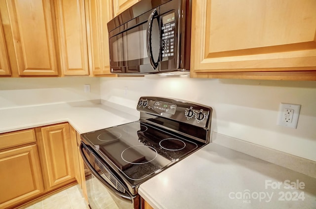 kitchen featuring black appliances and light tile patterned flooring