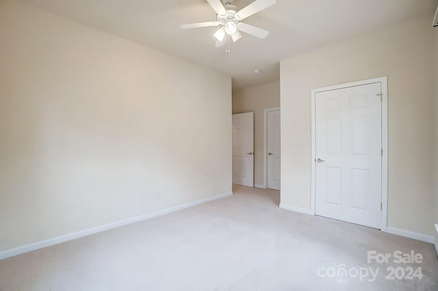 unfurnished bedroom with ceiling fan and light colored carpet