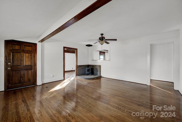 unfurnished living room with dark hardwood / wood-style floors, ceiling fan, a wood stove, and lofted ceiling with beams