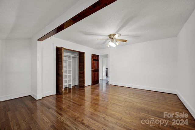 spare room with a textured ceiling, ceiling fan, and dark wood-type flooring