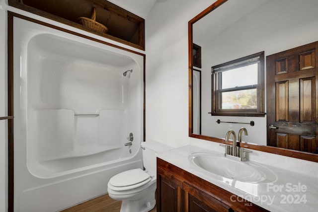 full bathroom with wood-type flooring, vanity, bathing tub / shower combination, and toilet