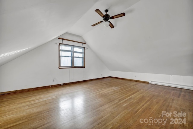 bonus room with ceiling fan, a baseboard heating unit, lofted ceiling, and light hardwood / wood-style flooring