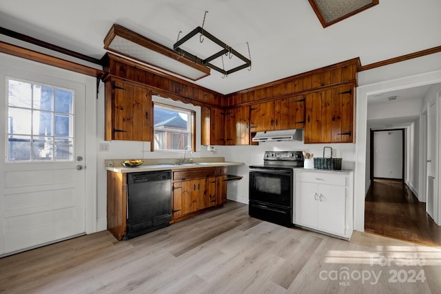 kitchen with crown molding, sink, black appliances, and light hardwood / wood-style floors