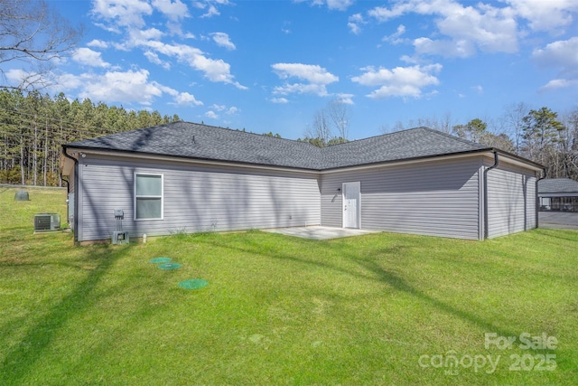 rear view of house featuring a yard, a shingled roof, a patio area, and cooling unit