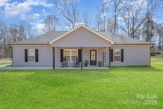 view of front of property with a shingled roof, a front lawn, and a patio